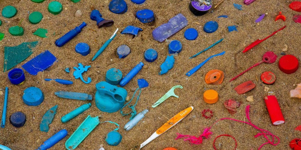 Color-coded plastic waste on a sandy beach